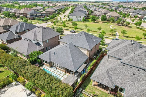 an aerial view of residential houses with outdoor space and parking