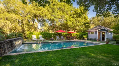 a view of a house with swimming pool and a yard
