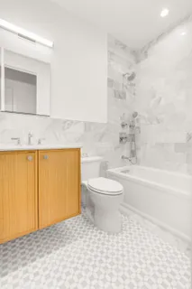 a bathroom with a toilet a sink a vanity and mirror