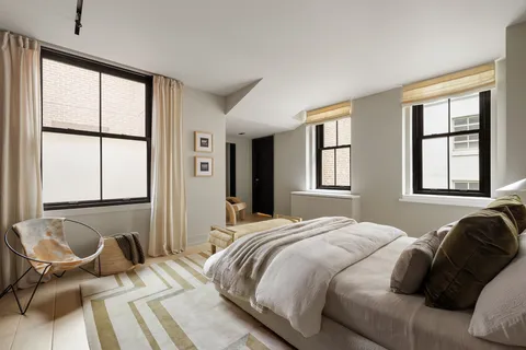 a bedroom with a bed and windows