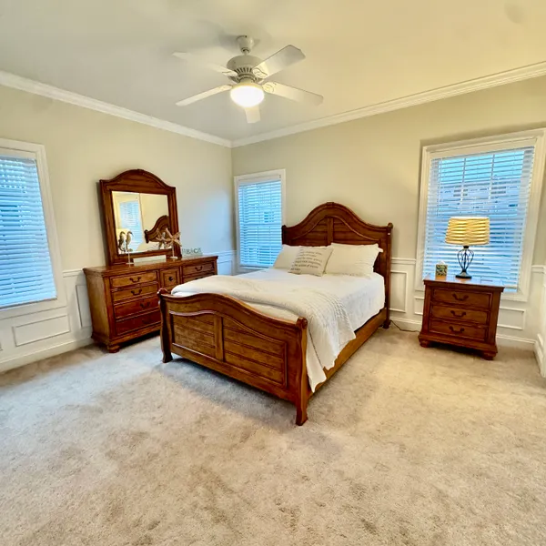 a bedroom with a bed and a flat tv screen on dresser