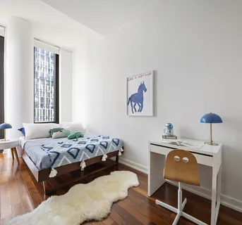 a bedroom with a bed and a chair with the wooden floor