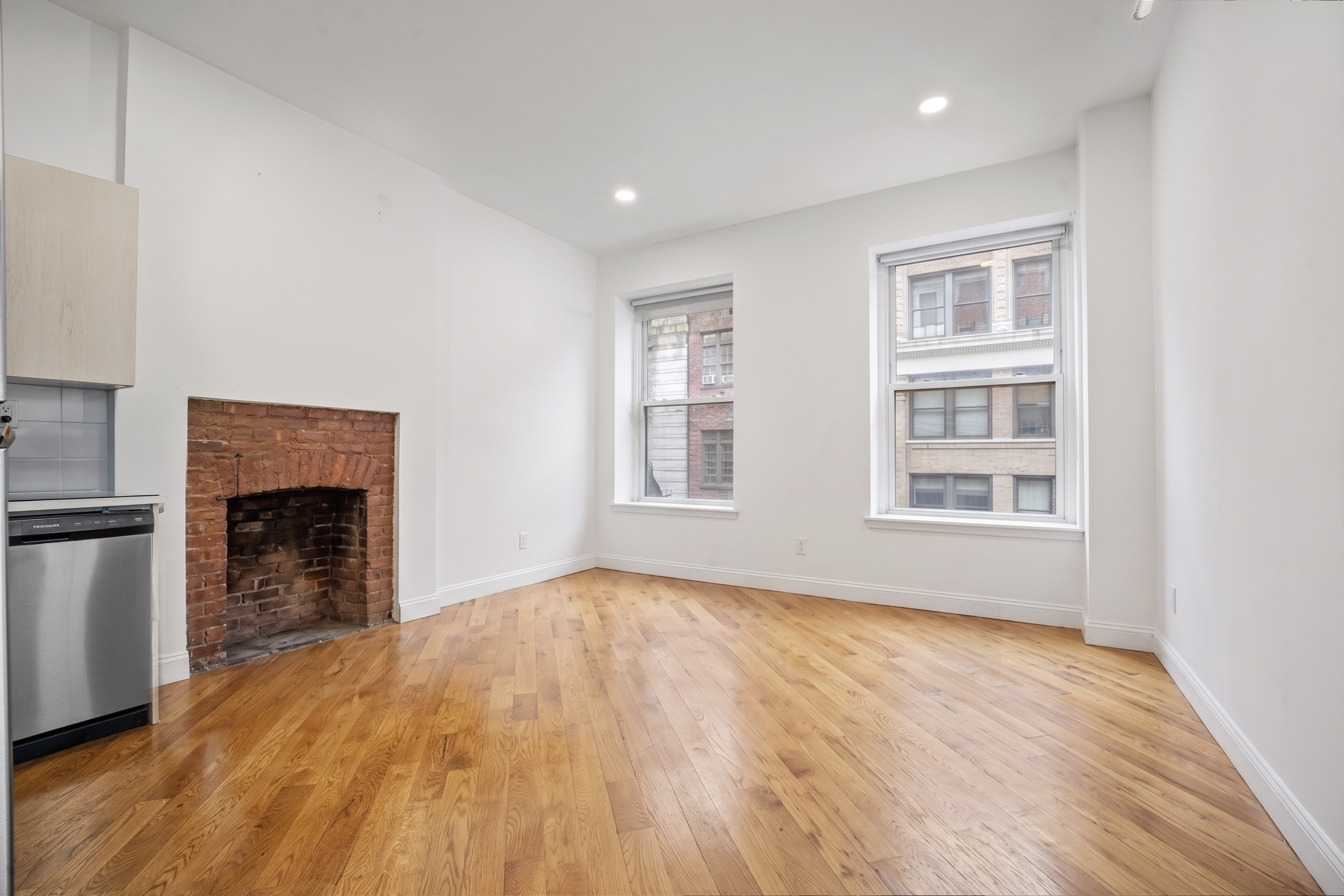 36 West 35th Street, Unit 2A Manhattan, NY 10001 - Photo 3 of 11 a view of empty room with wooden floor and fireplace