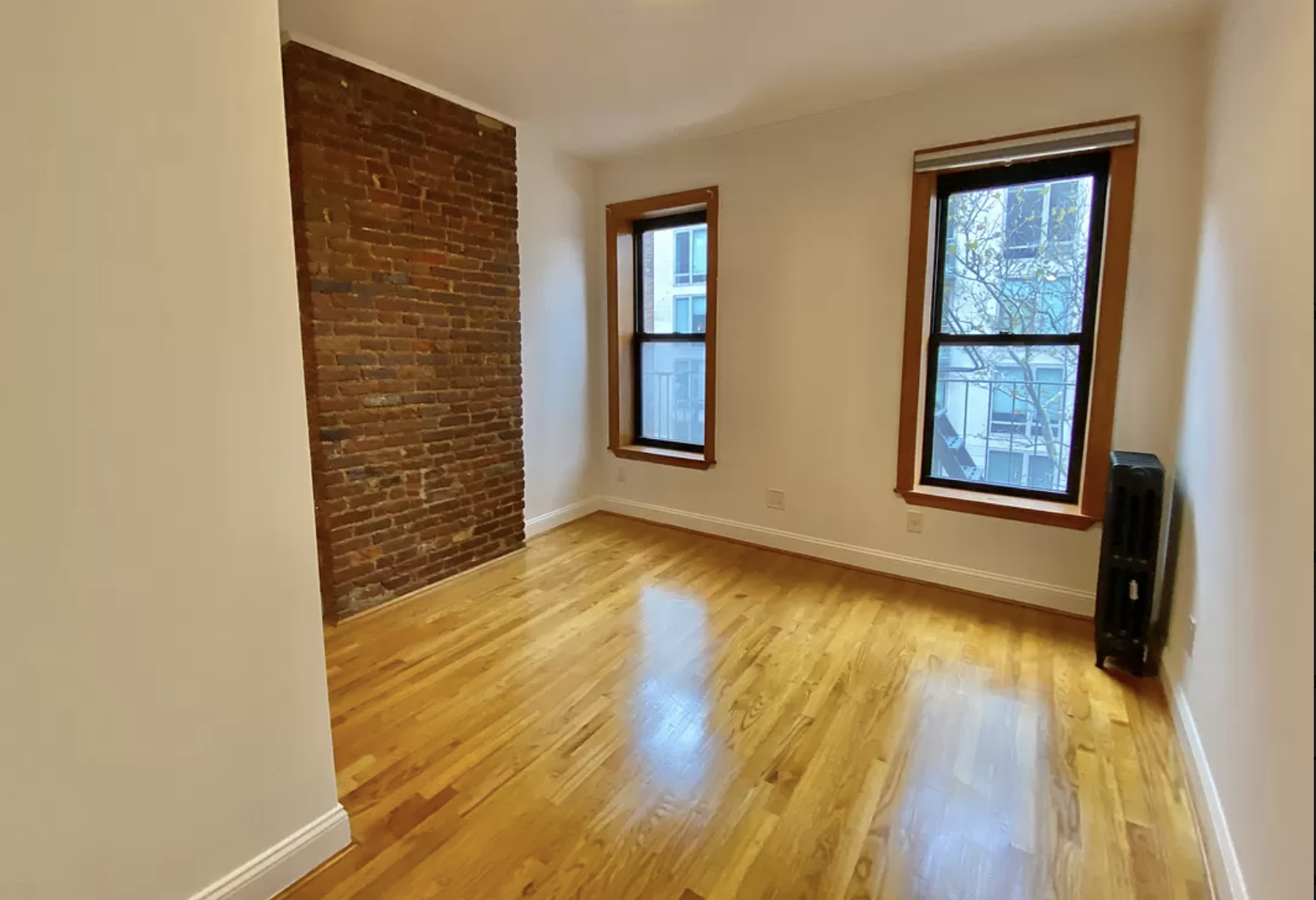 314 East 11th Street, Unit 3B Manhattan, NY 10003 - Photo 9 of 11 a view of an empty room with wooden floor and a window