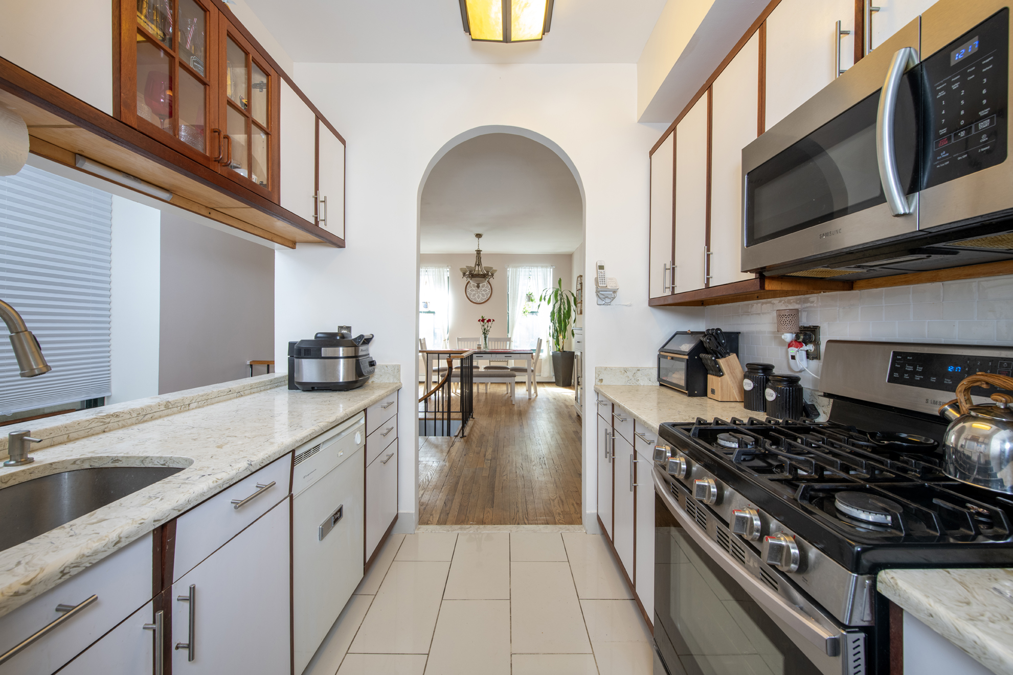352 West 117th Street, Unit 1E Manhattan, NY 10026 - Photo 2 of 13 a kitchen with stainless steel appliances granite countertop a stove a sink and a microwave