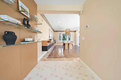 a view of a dining room and livingroom with furniture wooden floor a chandelier