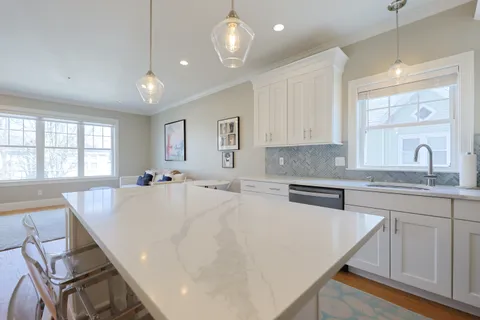 a large white kitchen with wooden floor