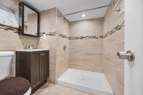 a bathroom with a sink a toilet and shower