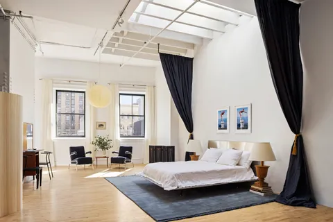 a bedroom with a bed couch and a window