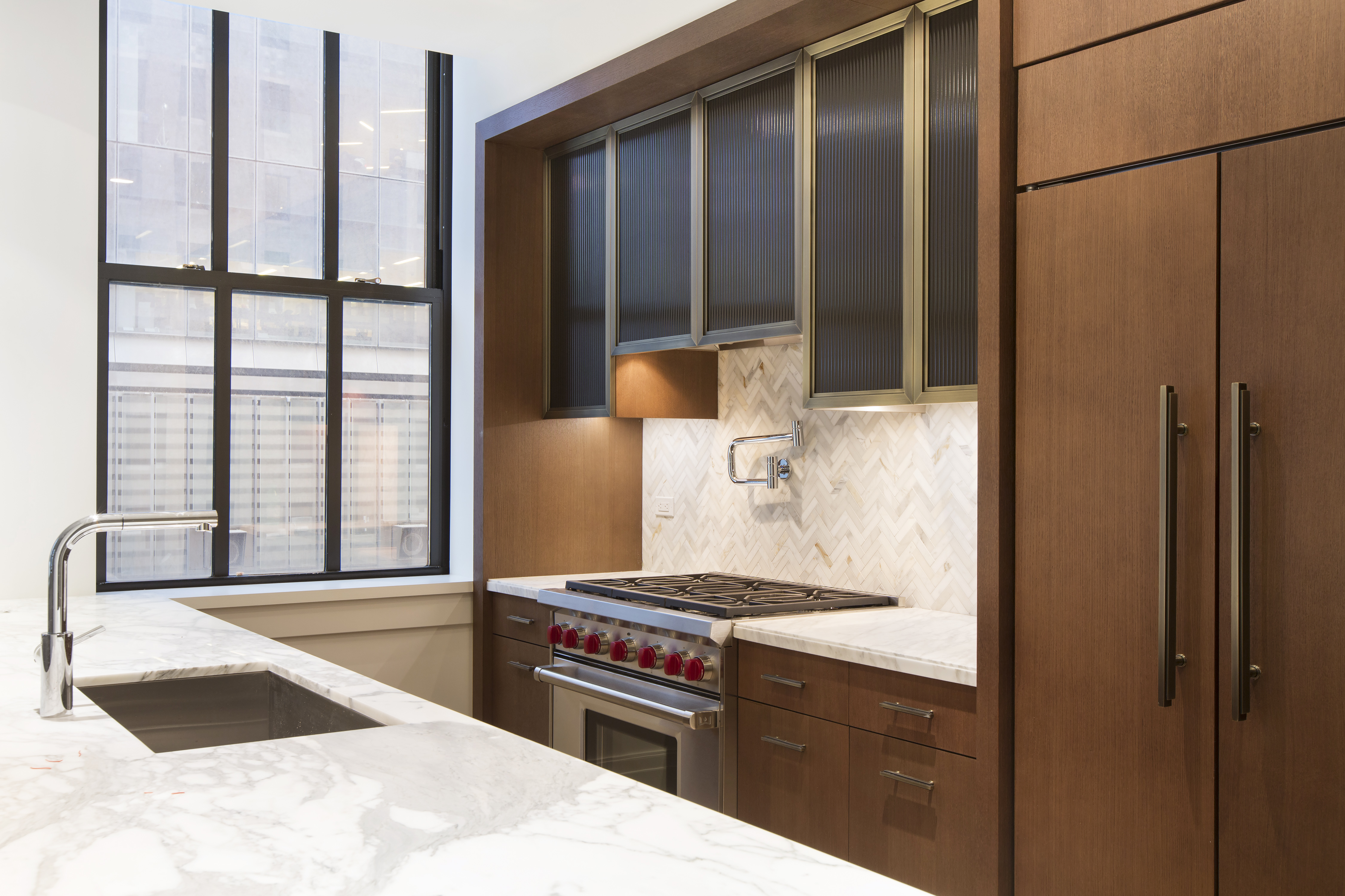100 Barclay Street, Unit 12L Manhattan, NY 10007 - Photo 3 of 7 a kitchen with stainless steel appliances kitchen island granite countertop a refrigerator and a sink