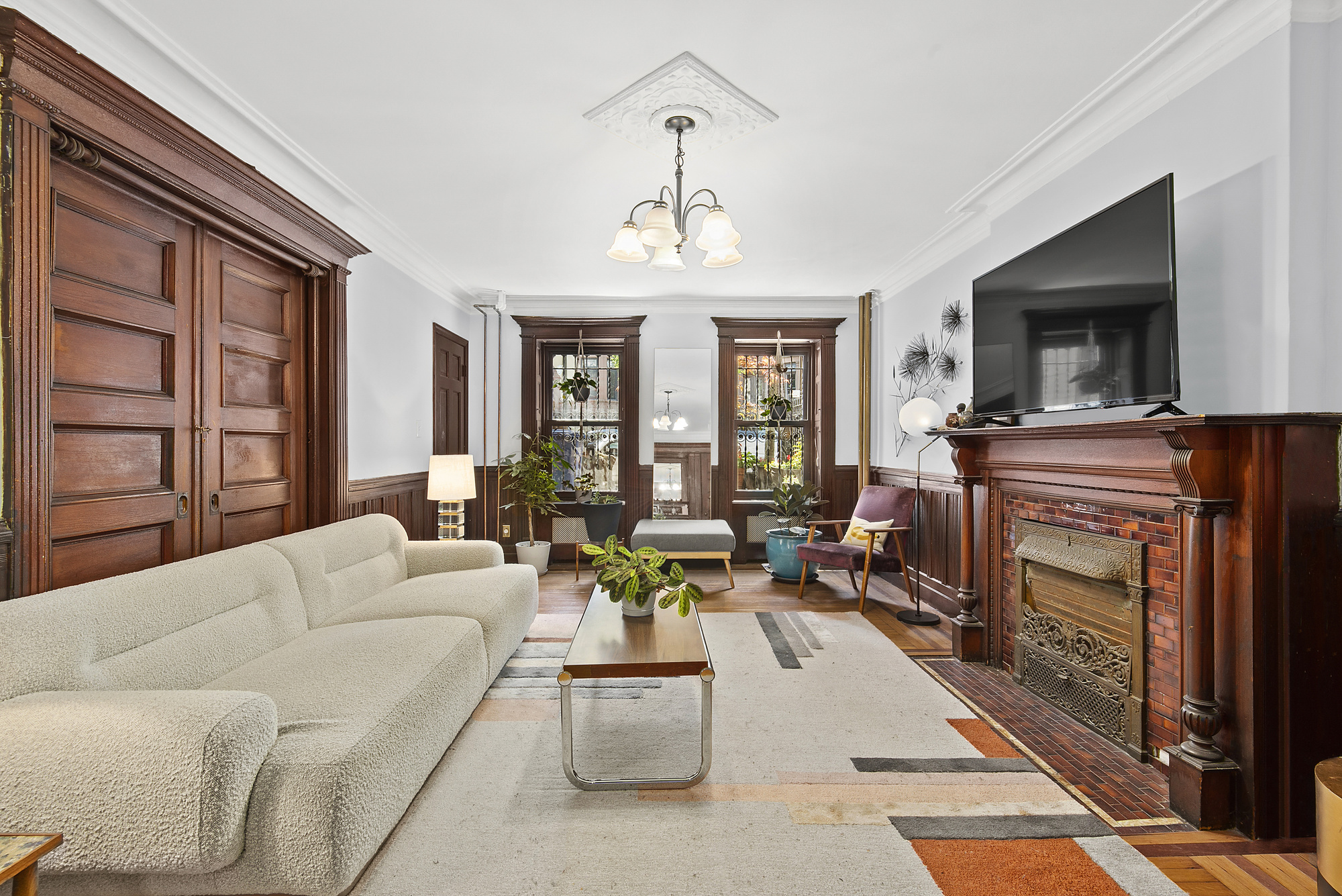 291 Sterling Place Brooklyn, NY 11238 - Photo 13 of 19 a living room with furniture a flat screen tv and a fireplace