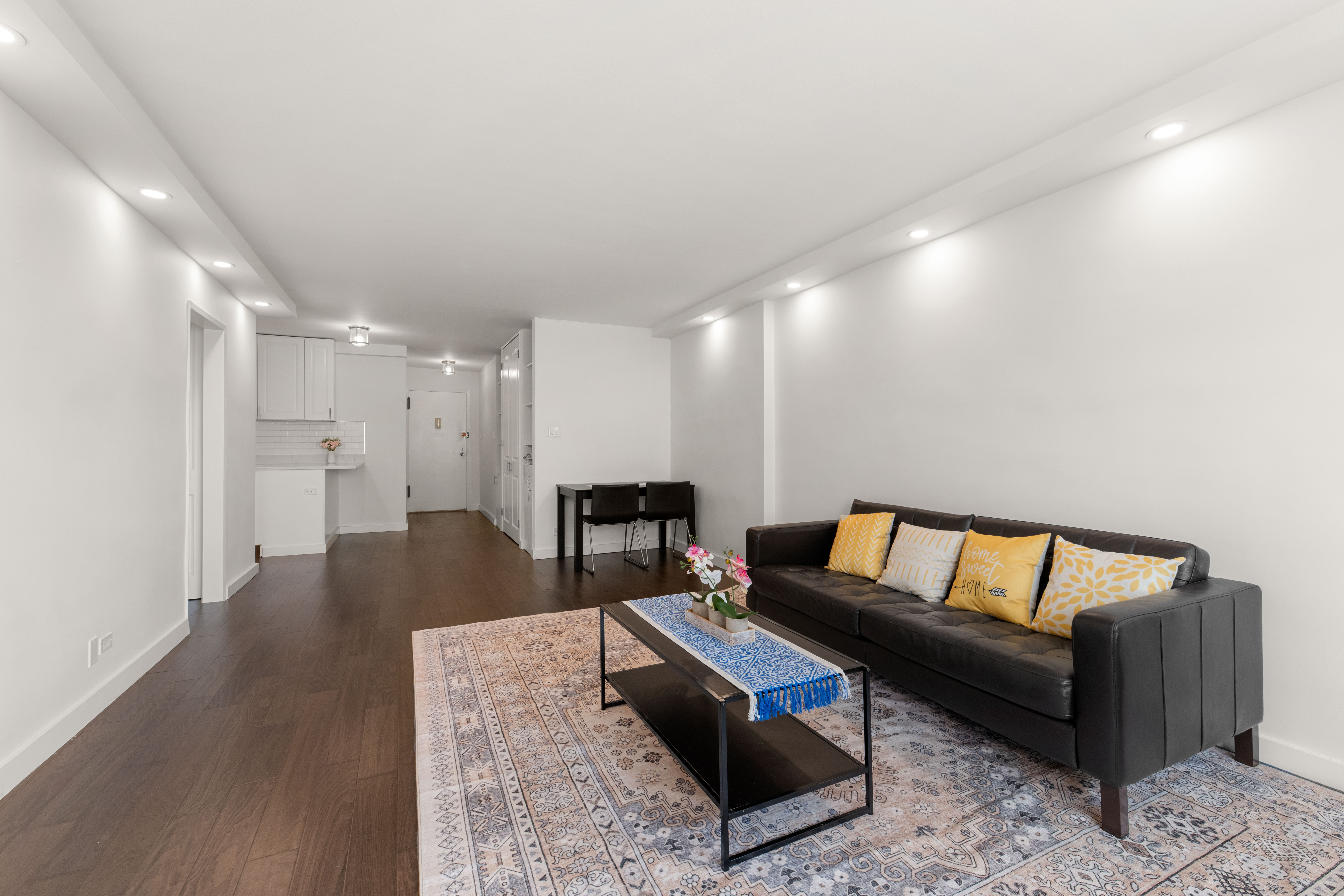66-36 Yellowstone Boulevard, Unit 24A Queens, NY 11375 - Photo 1 of 20 a living room with furniture and a dining table with wooden floor