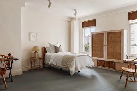 a spacious bedroom with a bed chair and a window