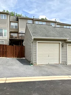 a front view of a house with a yard and a car parked on road