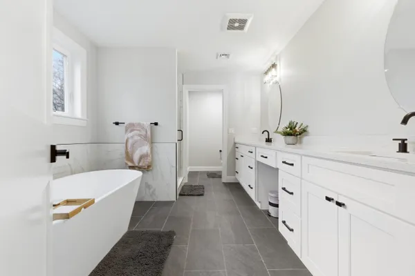 a bathroom with a double vanity sink a mirror and a bathtub