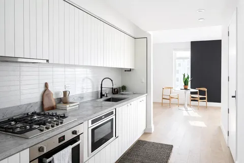 a kitchen with stainless steel appliances granite countertop a stove a sink and a white cabinets