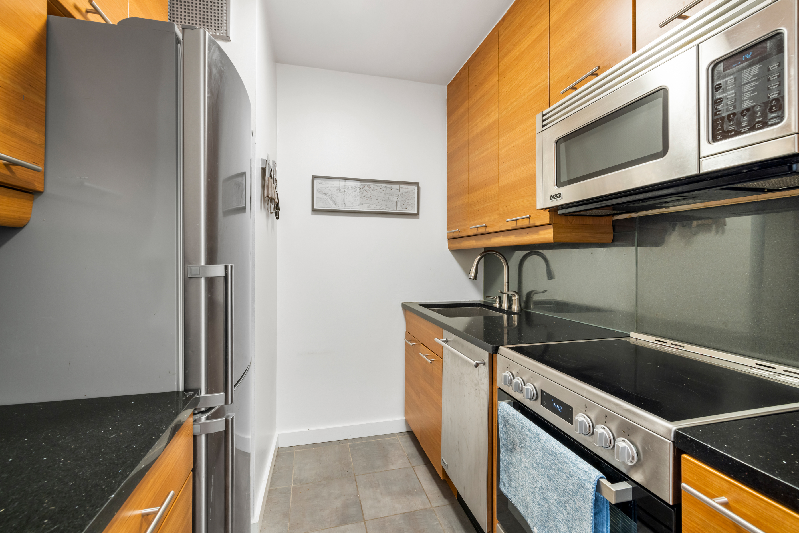 300 East 54th Street, Unit 23E Manhattan, NY 10022 - Photo 7 of 13 a kitchen that has a sink and a stove