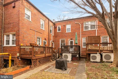 a view of a patio with couches table and chairs and wooden floor