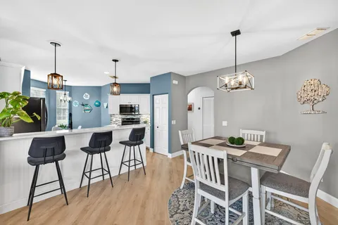 a view of a dining room with furniture wooden floor and chandelier