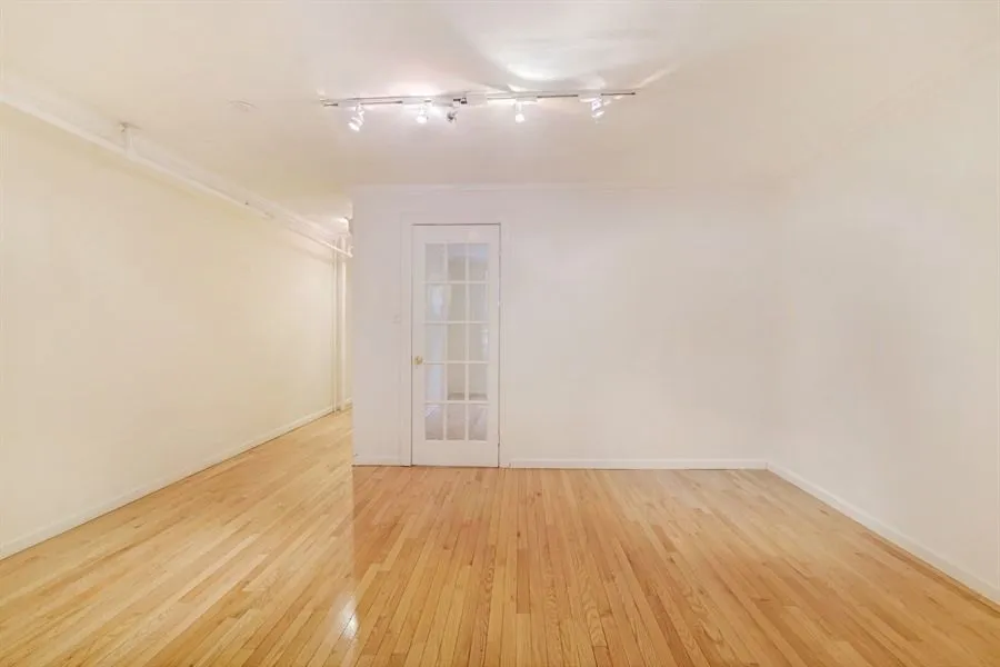 a view of empty room with wooden floor