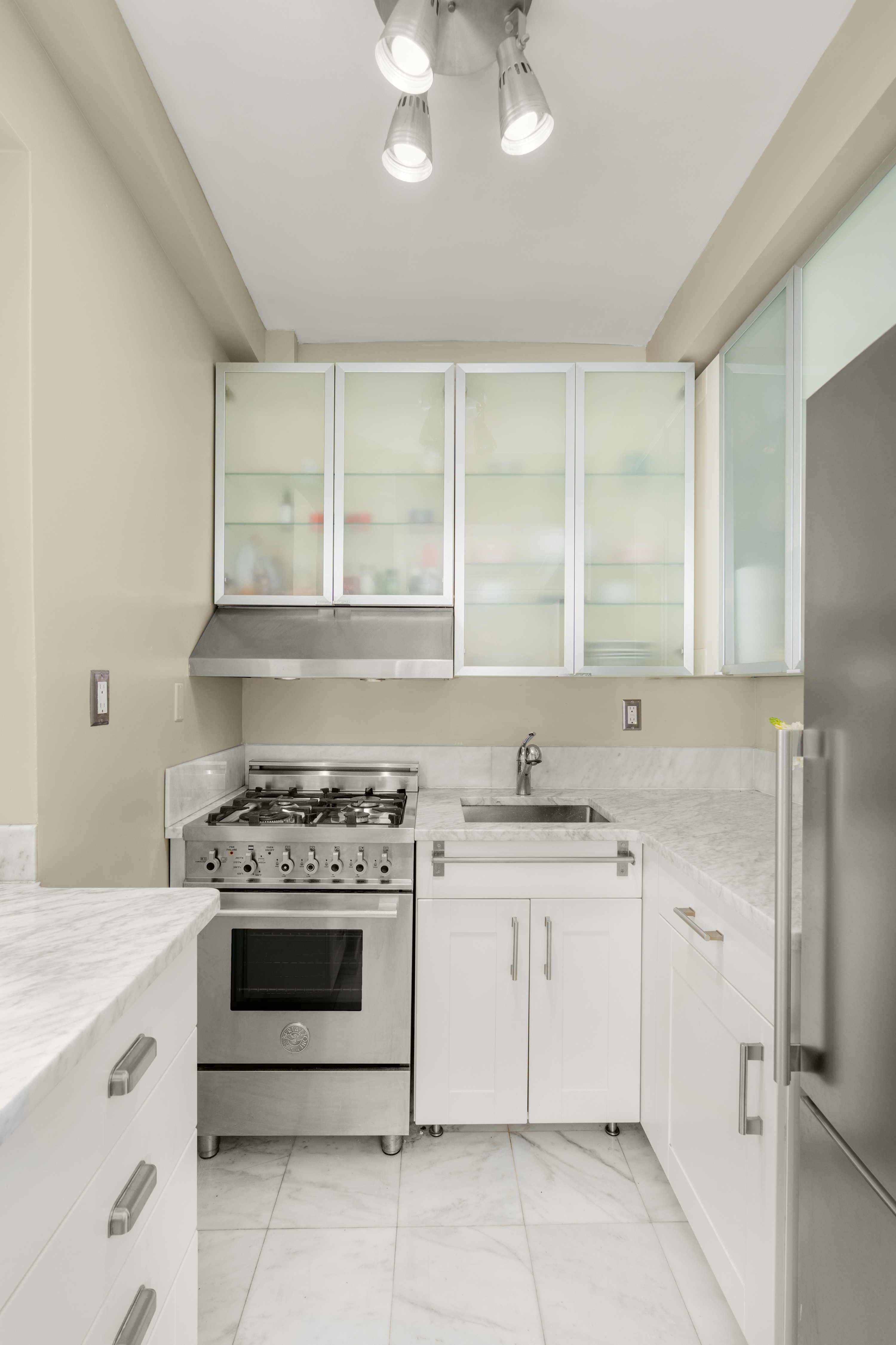 227 East 57th Street, Unit 2H Manhattan, NY 10022 - Photo 2 of 9 a kitchen with stainless steel appliances granite countertop a stove a sink and a refrigerator