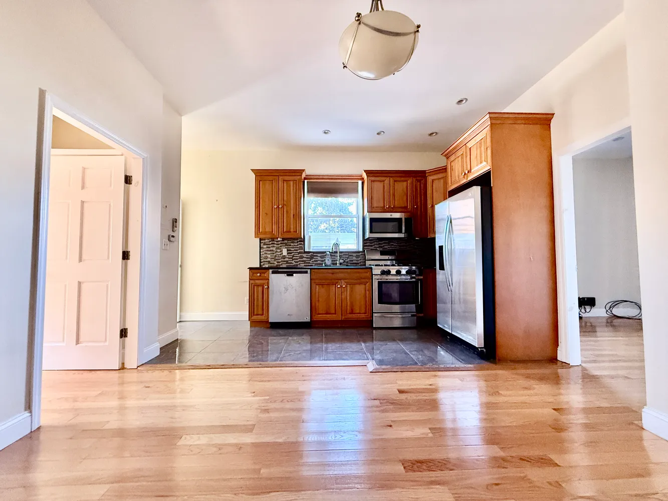 a view of kitchen with stainless steel appliances granite countertop a refrigerator and a stove top oven
