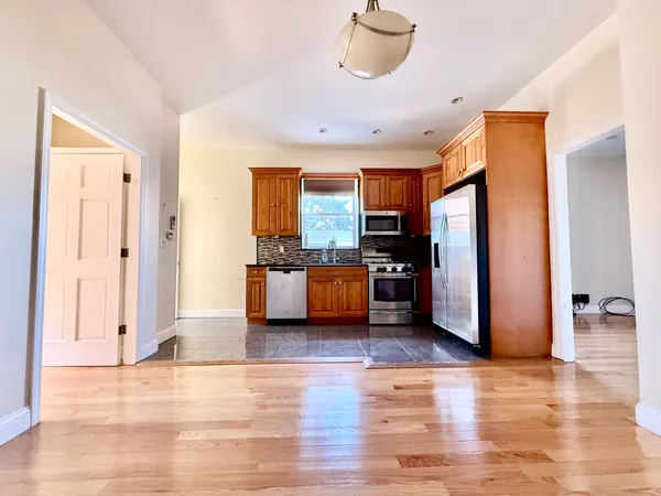 a view of kitchen with stainless steel appliances granite countertop a refrigerator and a stove top oven