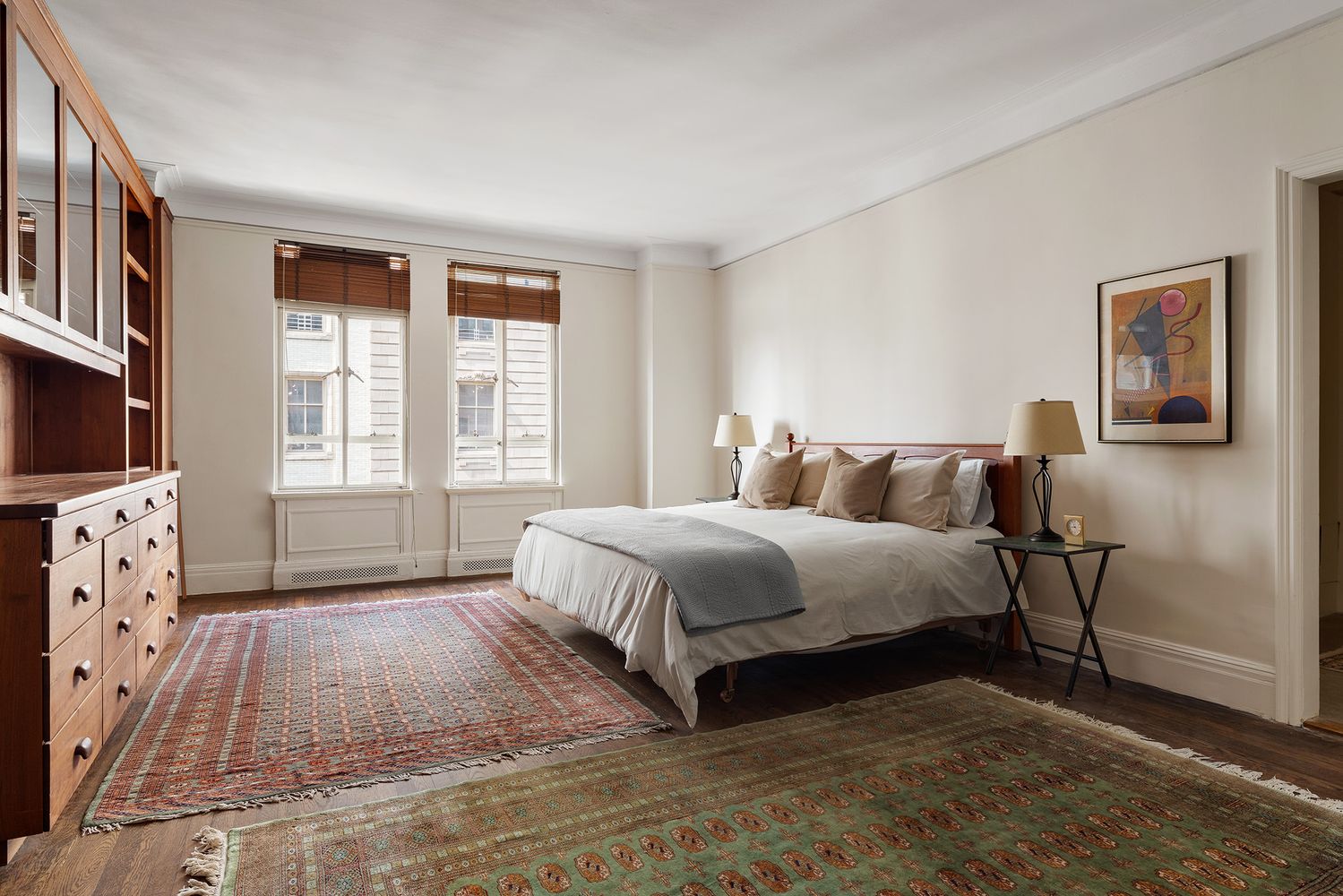 a spacious bedroom with a bed a couch and windows