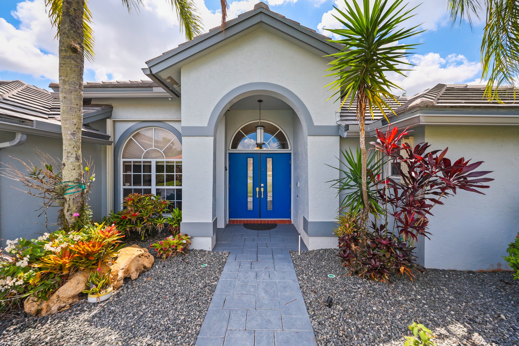 20317 Hacienda Court Boca Raton, FL 33498 - Photo 6 of 100 a front view of a house with a garden