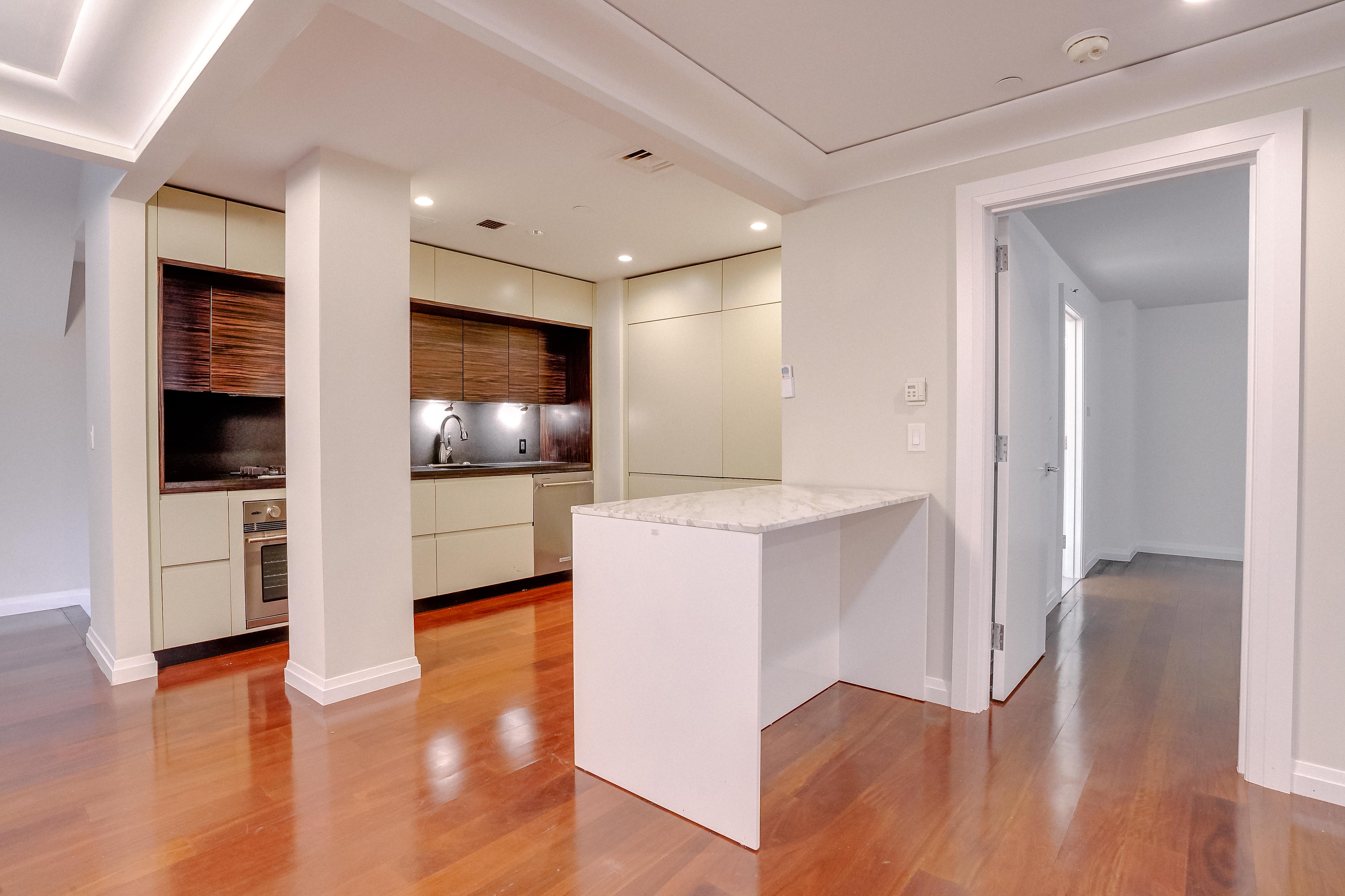 55 Wall Street, Unit PH910 Manhattan, NY 10005 - Photo 3 of 19 a view of kitchen with wooden floor and electronic appliances