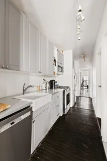 a kitchen with granite countertop white cabinets and white appliances