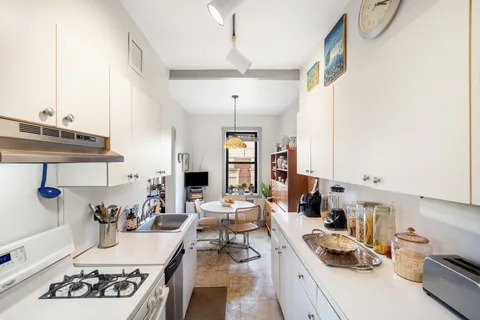 a kitchen with kitchen island granite countertop a sink stove and cabinets