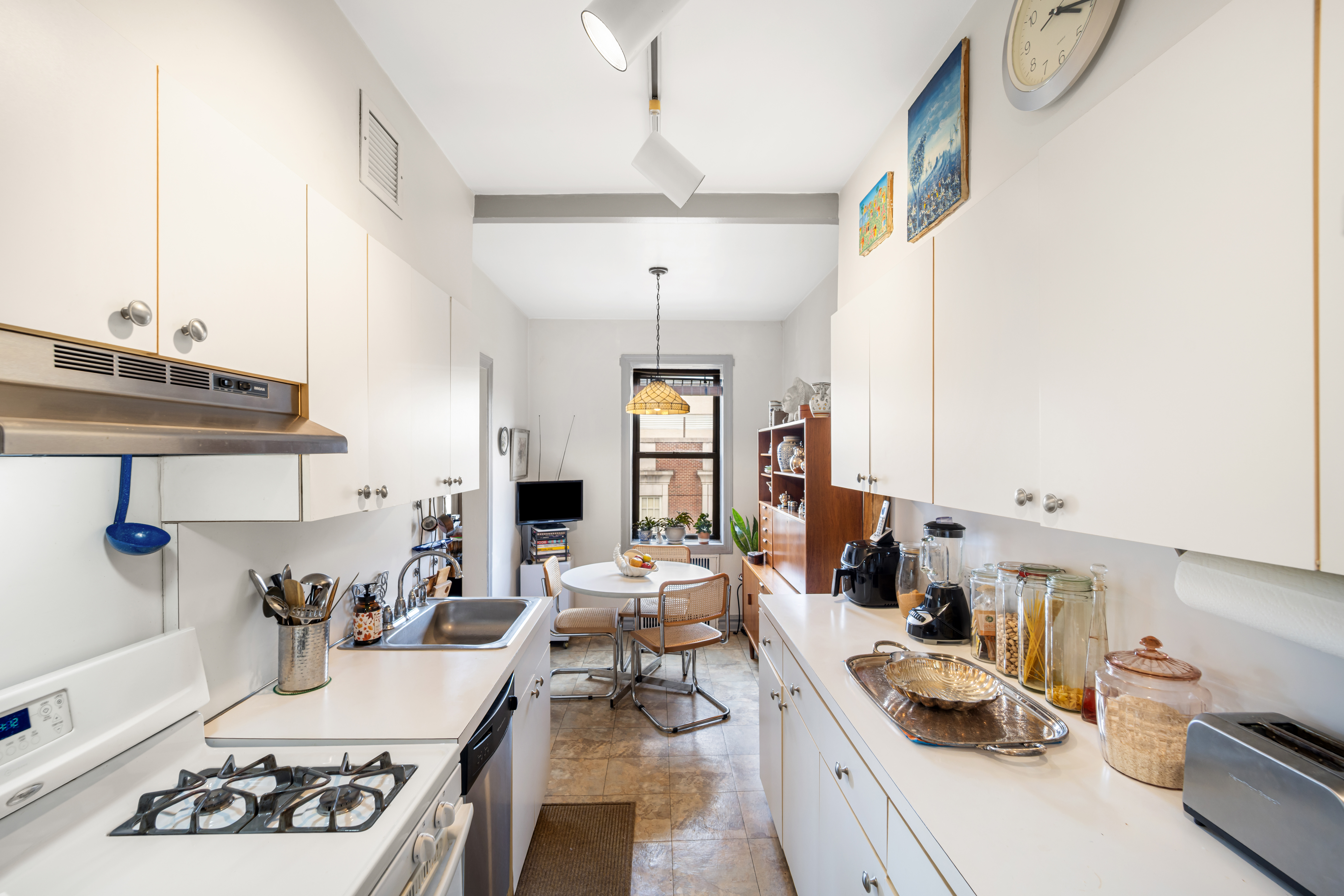 34-24 82nd Street, Unit 6N Queens, NY 11372 - Photo 5 of 15 a kitchen with kitchen island granite countertop a sink stove and cabinets