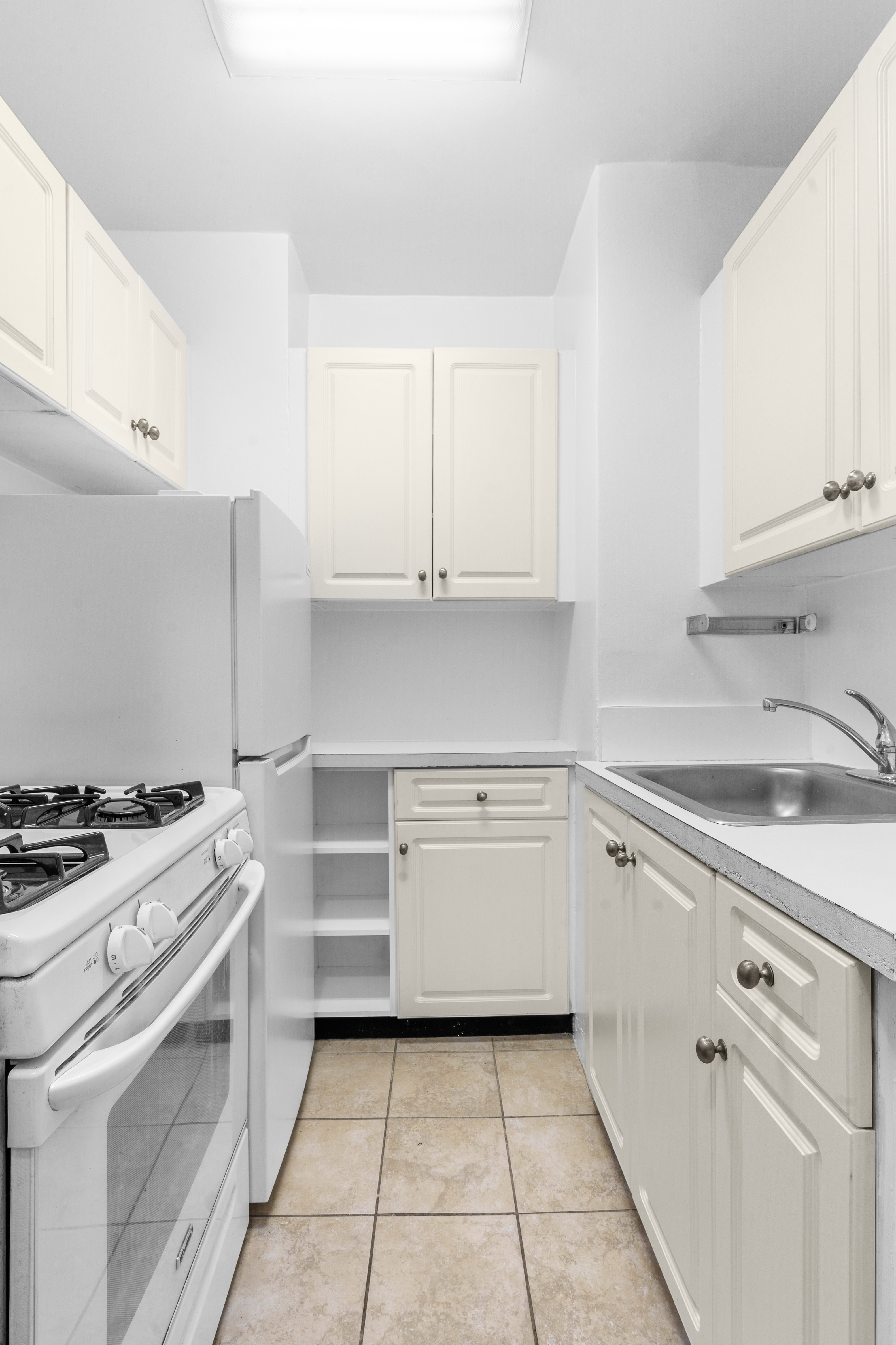 101 West 12th Street, Unit 3Z Manhattan, NY 10011 - Photo 3 of 7 a kitchen with granite countertop cabinets and white appliances