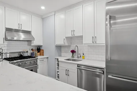 a kitchen with cabinets stainless steel appliances and a sink