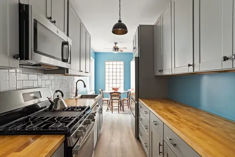a kitchen with stainless steel appliances granite countertop a stove a sink and a microwave