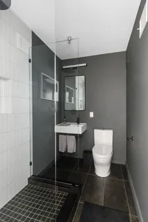 a bathroom with a toilet a sink and mirror
