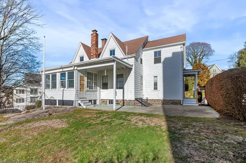 a view of a white house with a yard and large windows