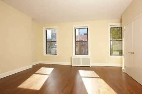 a view of a room with wooden floor and windows