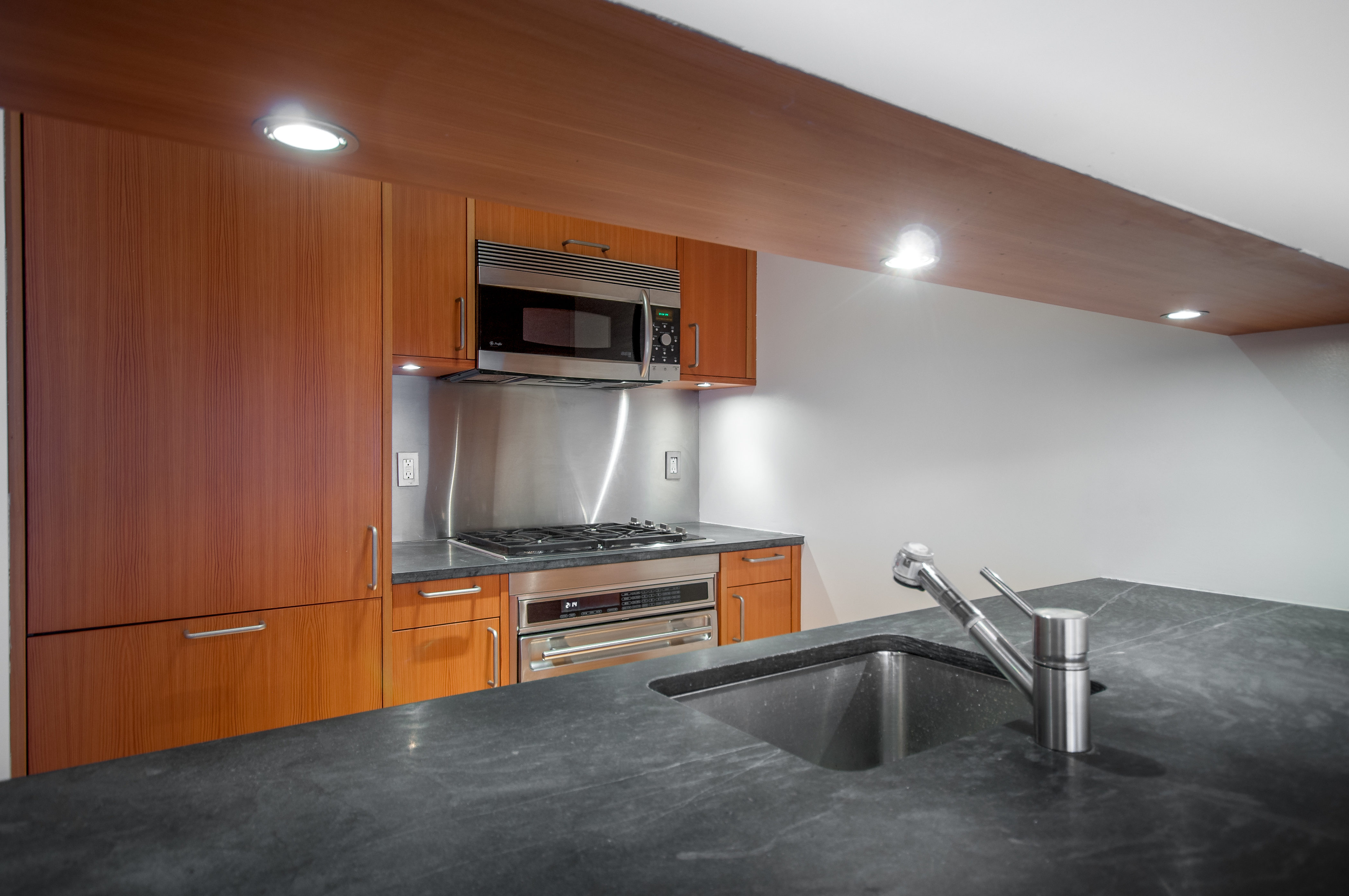 450 East 83rd Street, Unit 3D Manhattan, NY 10028 - Photo 10 of 15 a kitchen with stainless steel appliances a microwave a stove and a sink