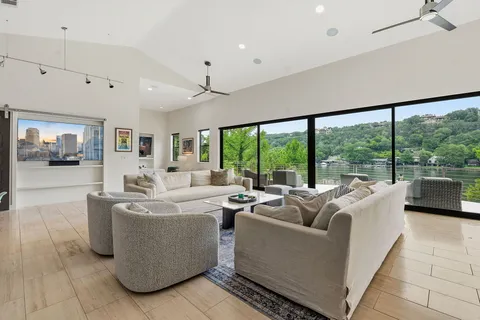 a living room with furniture kitchen view and a chandelier