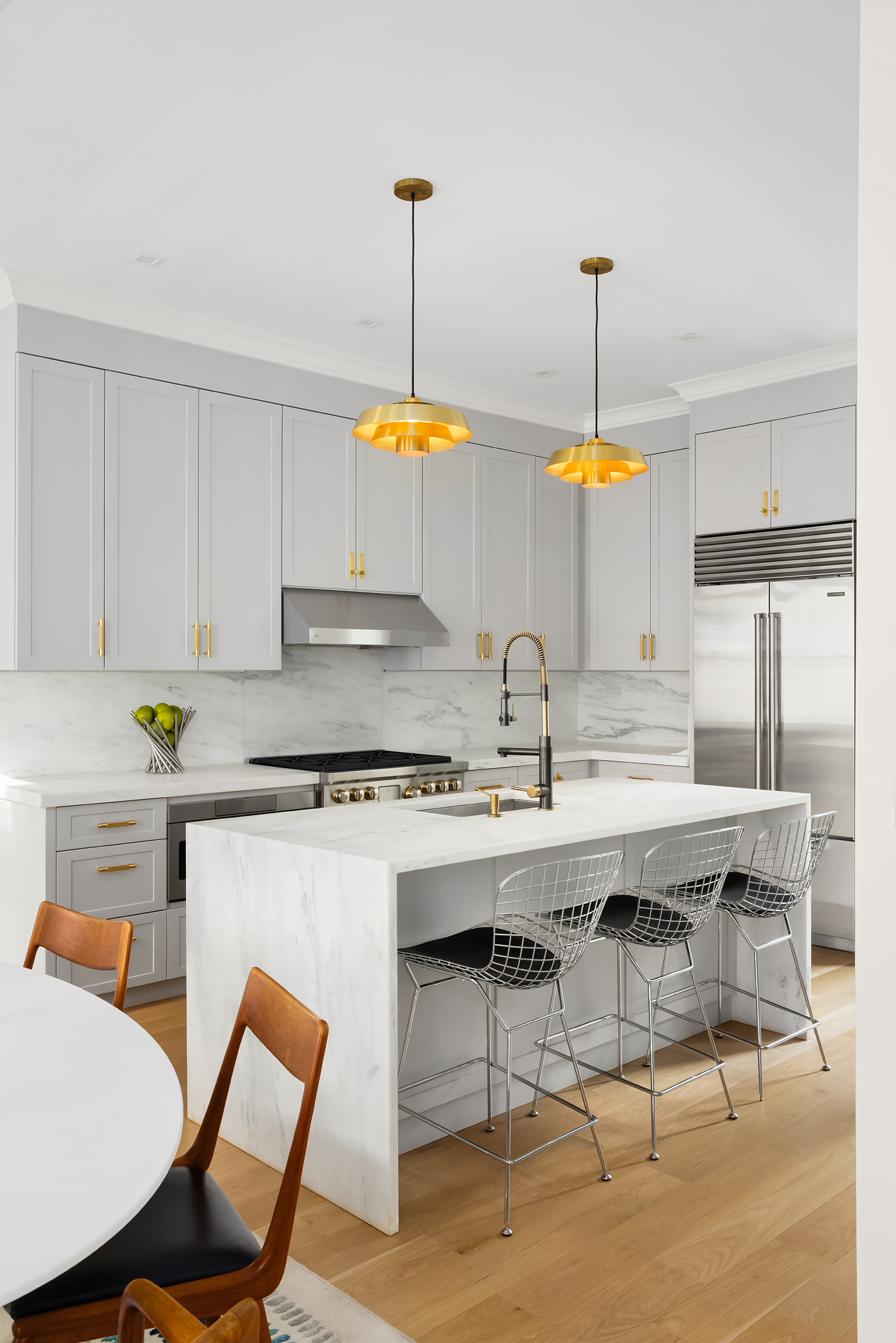 130 East 38th Street Manhattan, NY 10016 - Photo 4 of 16 a kitchen with stainless steel appliances granite countertop a table chairs and a sink