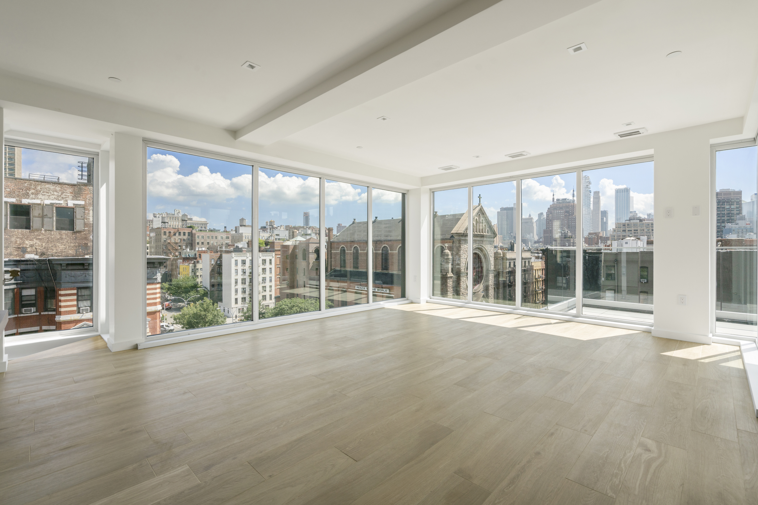 136 West Houston Street, Unit PH Manhattan, NY 10012 - Photo 2 of 26 a view of an empty room with wooden floor and a window