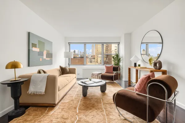 a living room with furniture a mirror and a window