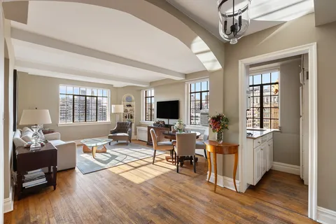 a living room with furniture flat screen tv and wooden floor