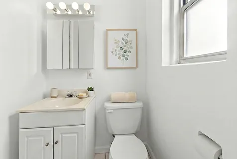 a bathroom with a toilet a sink and a window