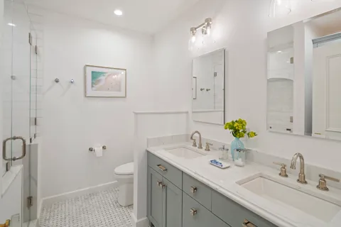 a bathroom with a sink a toilet and a mirror