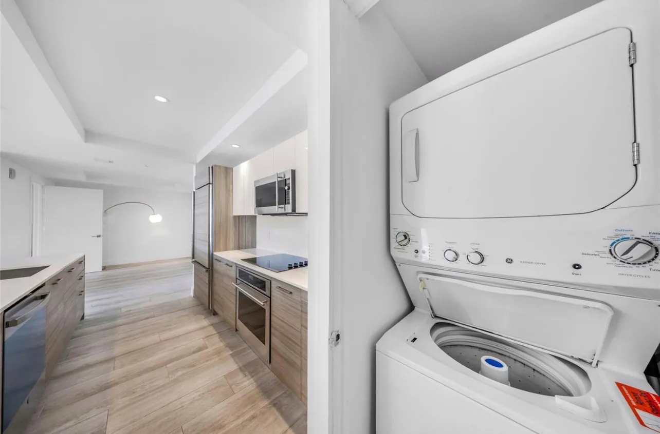 a view of washer and dryer with bathroom in the background
