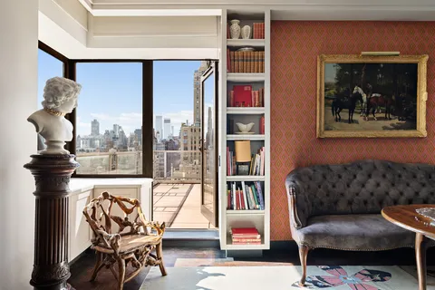 a view of a livingroom with furniture and a book shelf