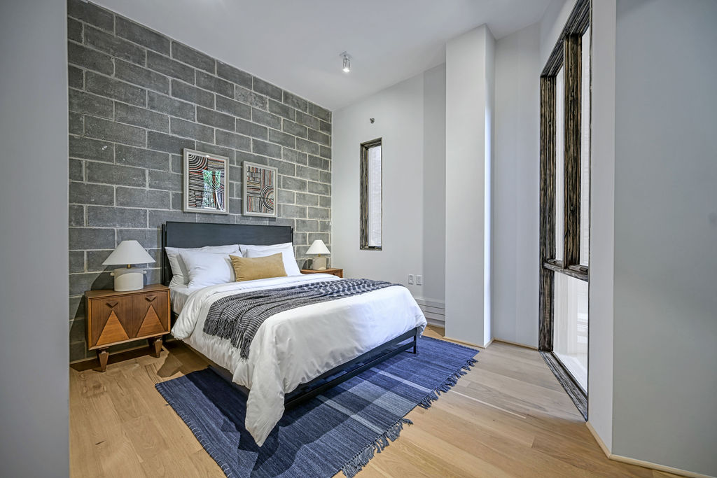 459 Harman Street, Unit 1 Manhattan, NY 10026 - Photo 8 of 17 a bedroom with a bed lamp and a fireplace